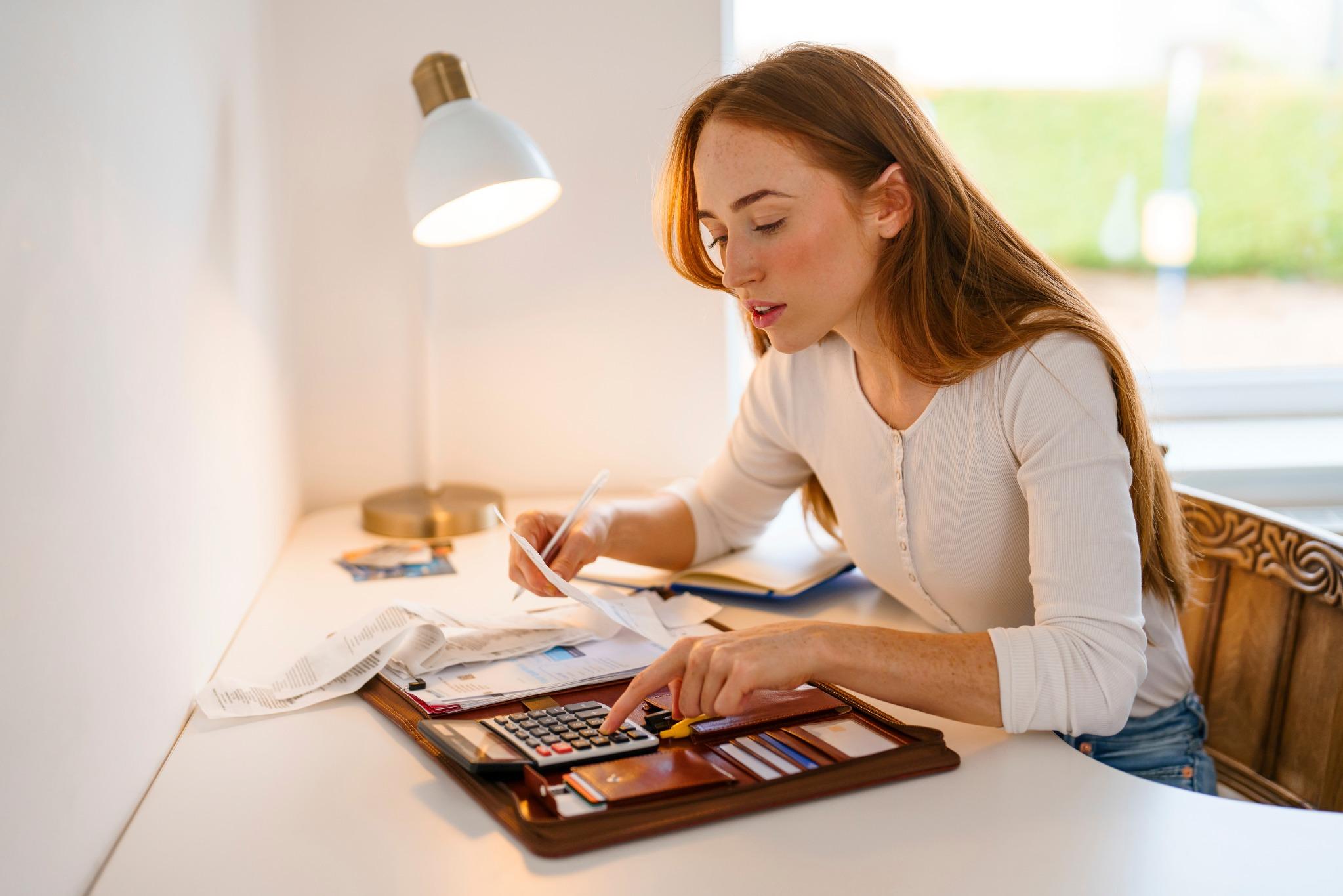 mulher organizando contas e calculando orçamento doméstico em casa